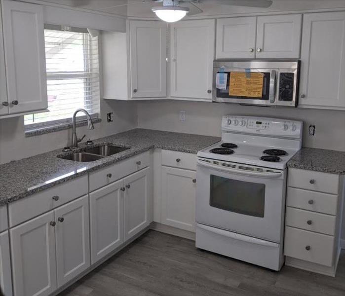 Kitchen with white cabinets and grey flooring