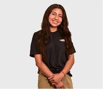 Female in black shirt standing in front of white background