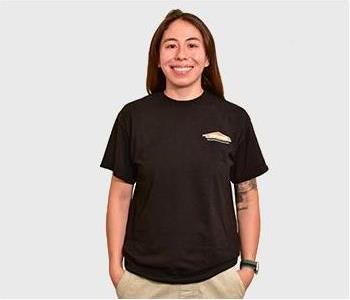 Female in black shirt standing in front of white background