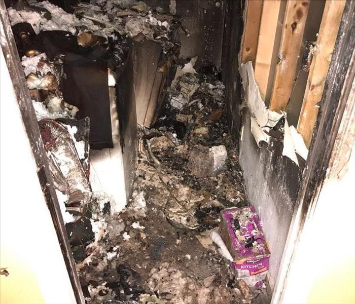 laundry room with melted appliances and debri from fire